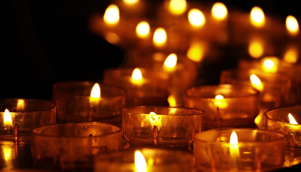 Nahaufnahme von Händen mit Räucherbündel; feiner Rauch im warmen Abendlicht, ruhig, editorial